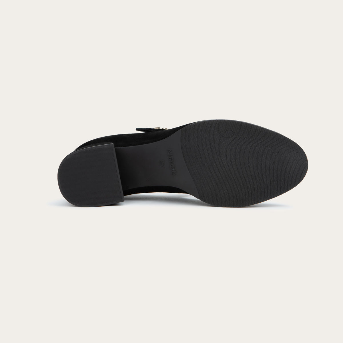 Bottom view of a black suede Mary Jane shoe with a rounded toe, a low block heel, and a thin strap across the instep secured by a polished gold-tone metal buckle.