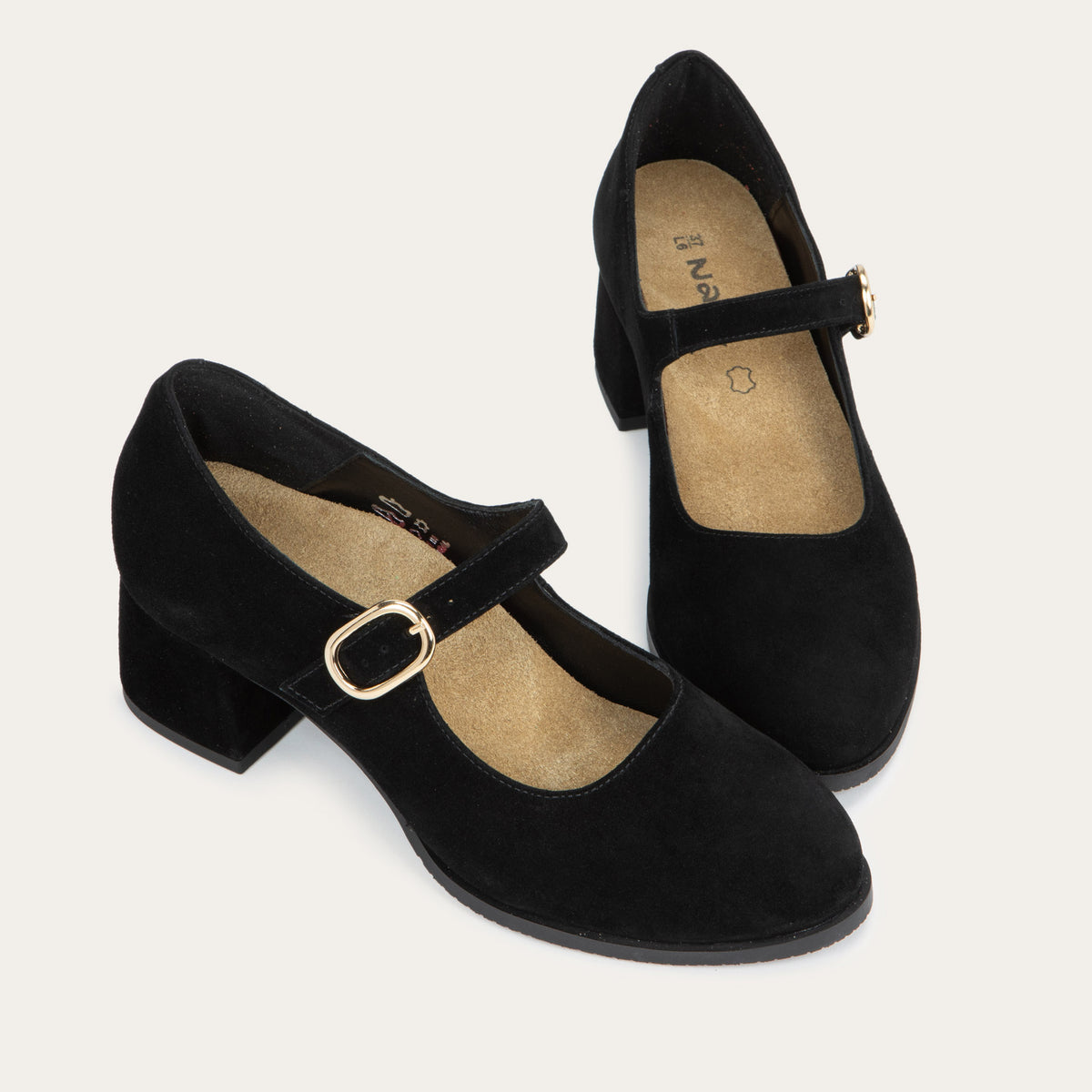 A pair of of black suede Mary Jane shoes with rounded toes, low block heels, and thin straps across the insteps secured by polished gold-tone metal buckles.