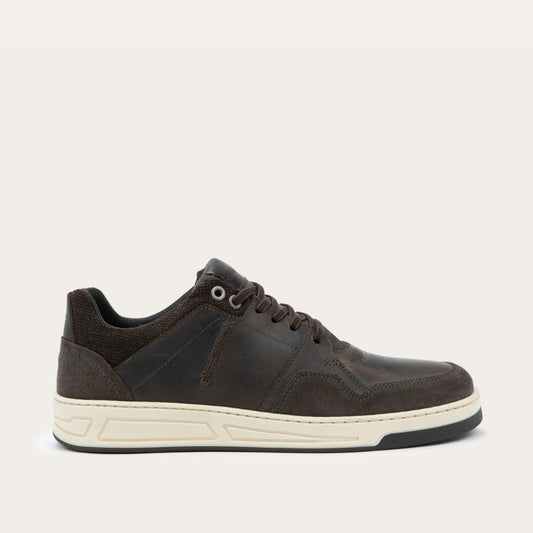 Side view of a gray sneaker with brown accents on a white sole.