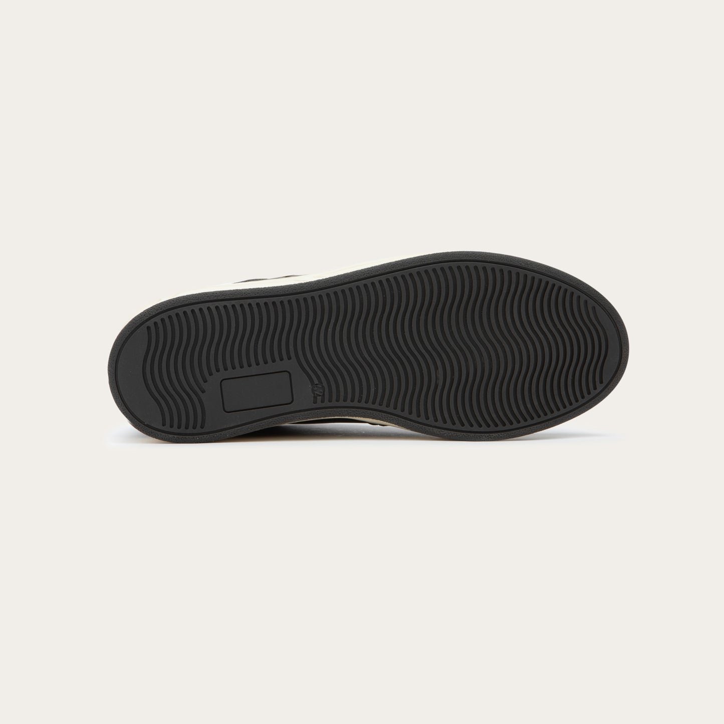 Bottom view of a gray sneaker with brown accents on a white sole.