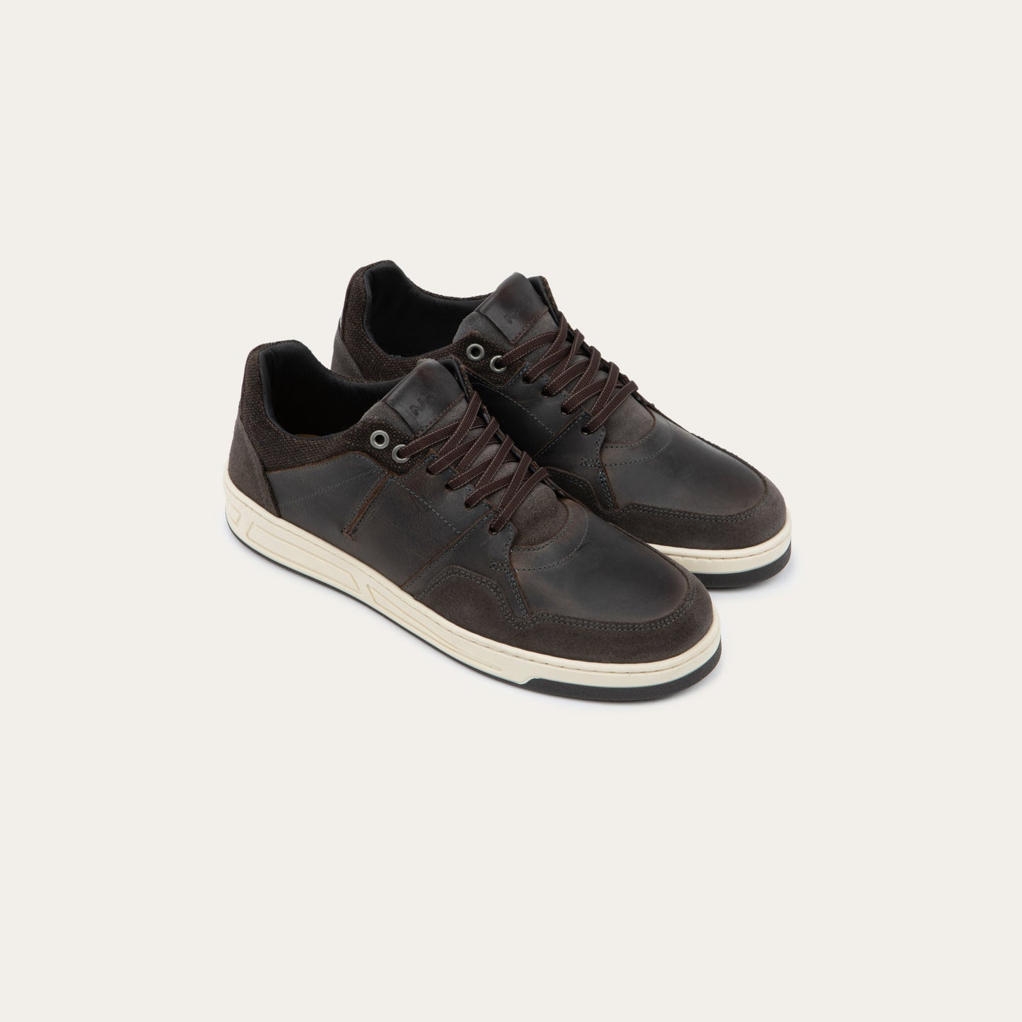 Pair of gray sneakers with brown accents on a white sole.