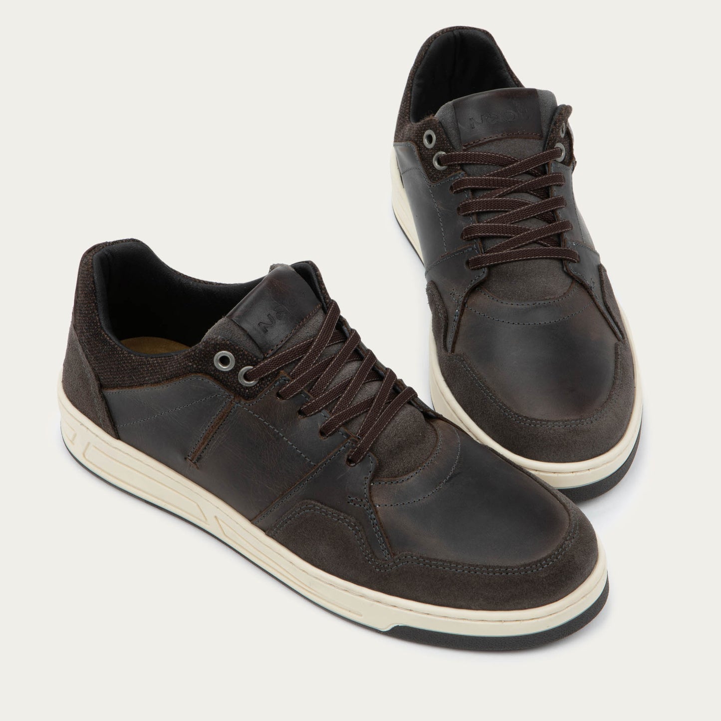 Pair of gray sneakers with brown accents on a white sole.