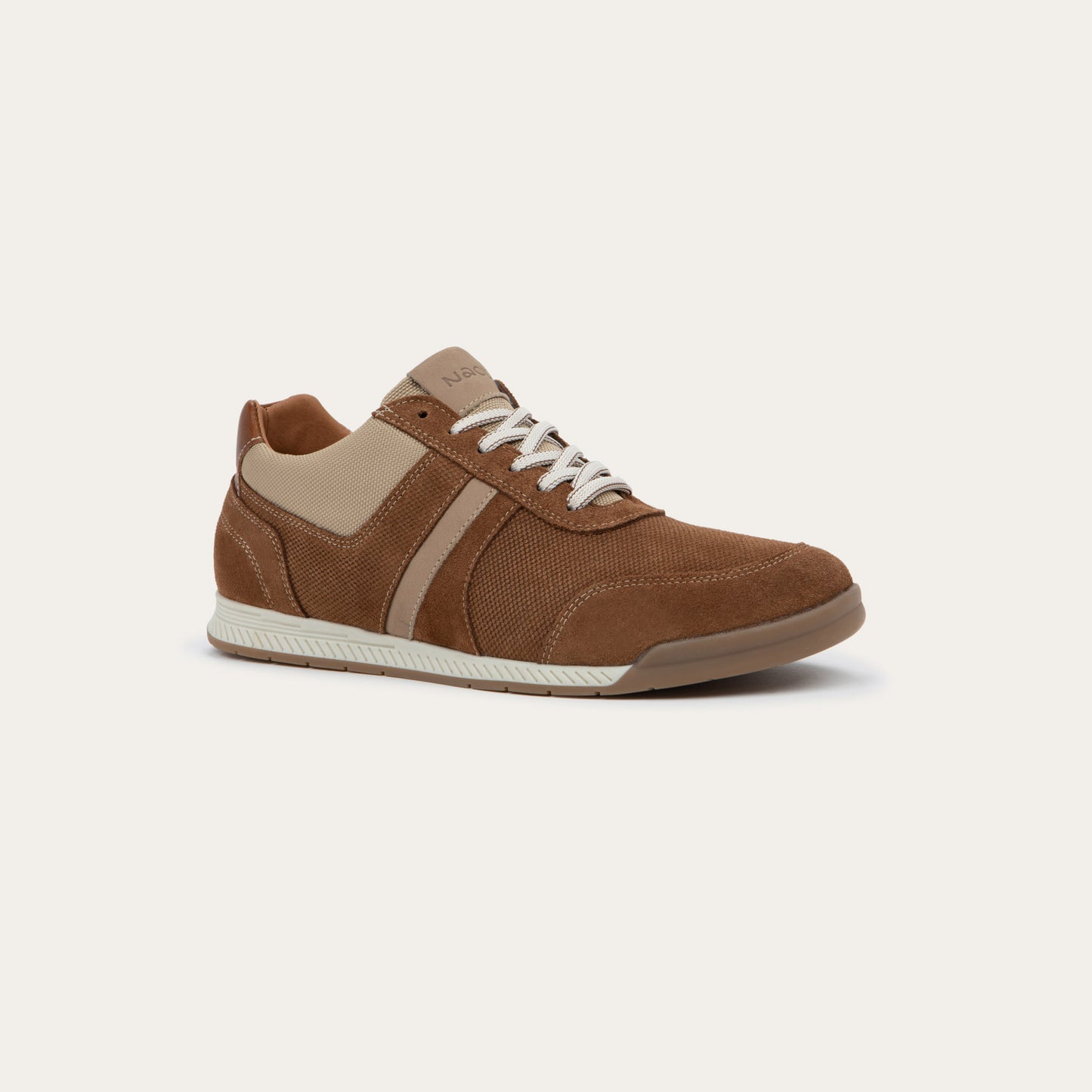 Angled profile view of a brown and beige sneaker on a brown sole.