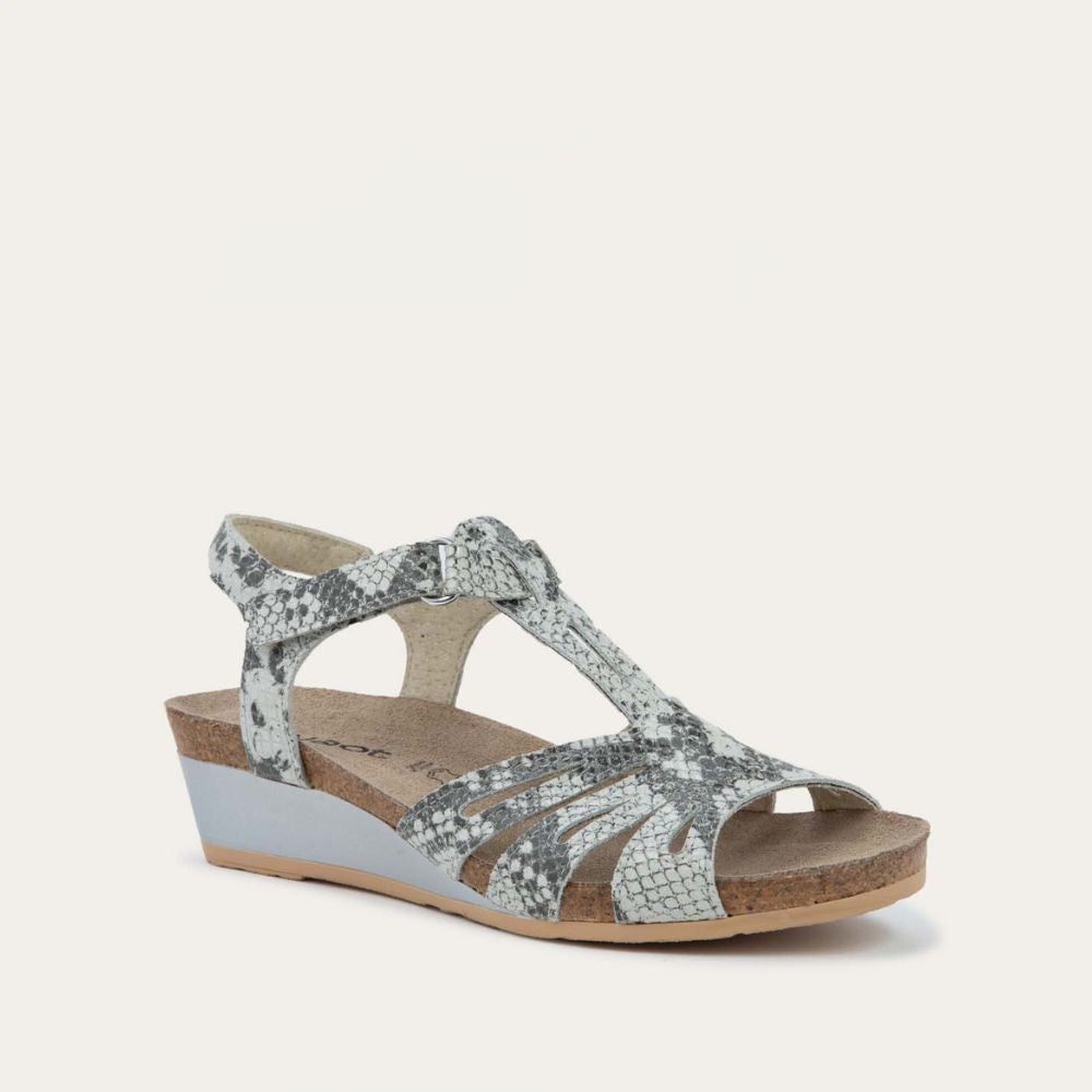 Angled profile view of a  black wedge sandal with strappy design, open toe, and adjustable ankle strap on a cork footbed.