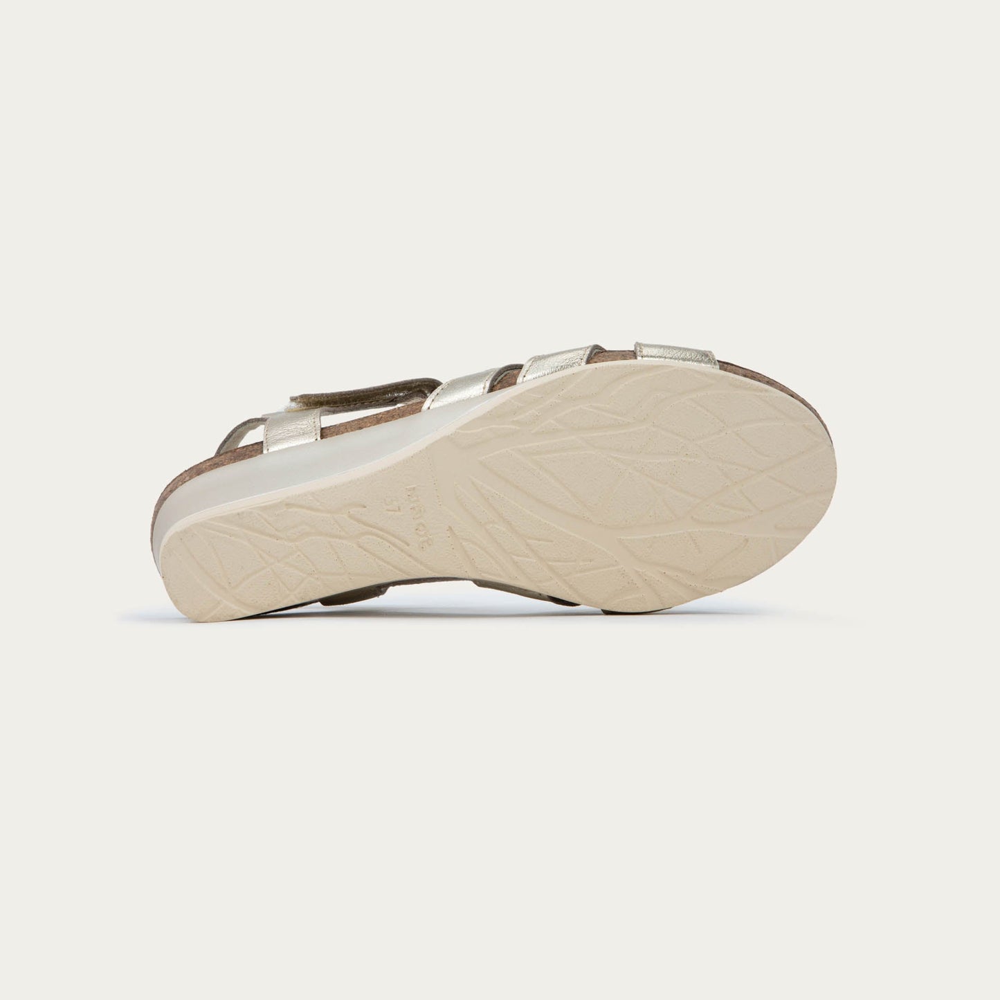 A pair of gold wedge sandals with strappy design, open toe, and adjustable ankle strap on a cork footbed.