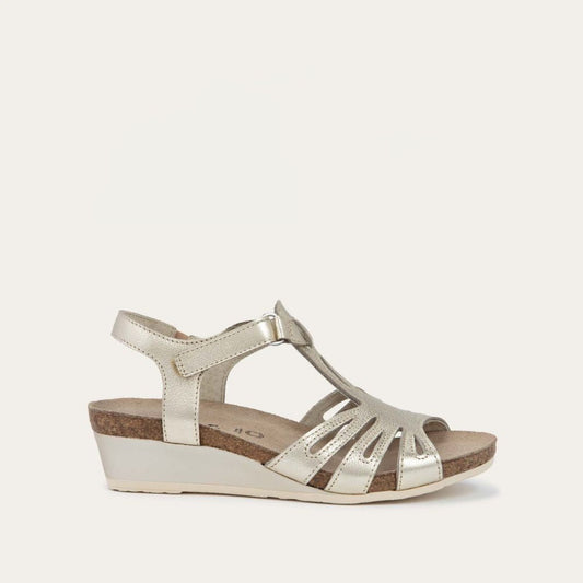 Angled profile view of a gold wedge sandal with strappy design, open toe, and adjustable ankle strap on a cork footbed.