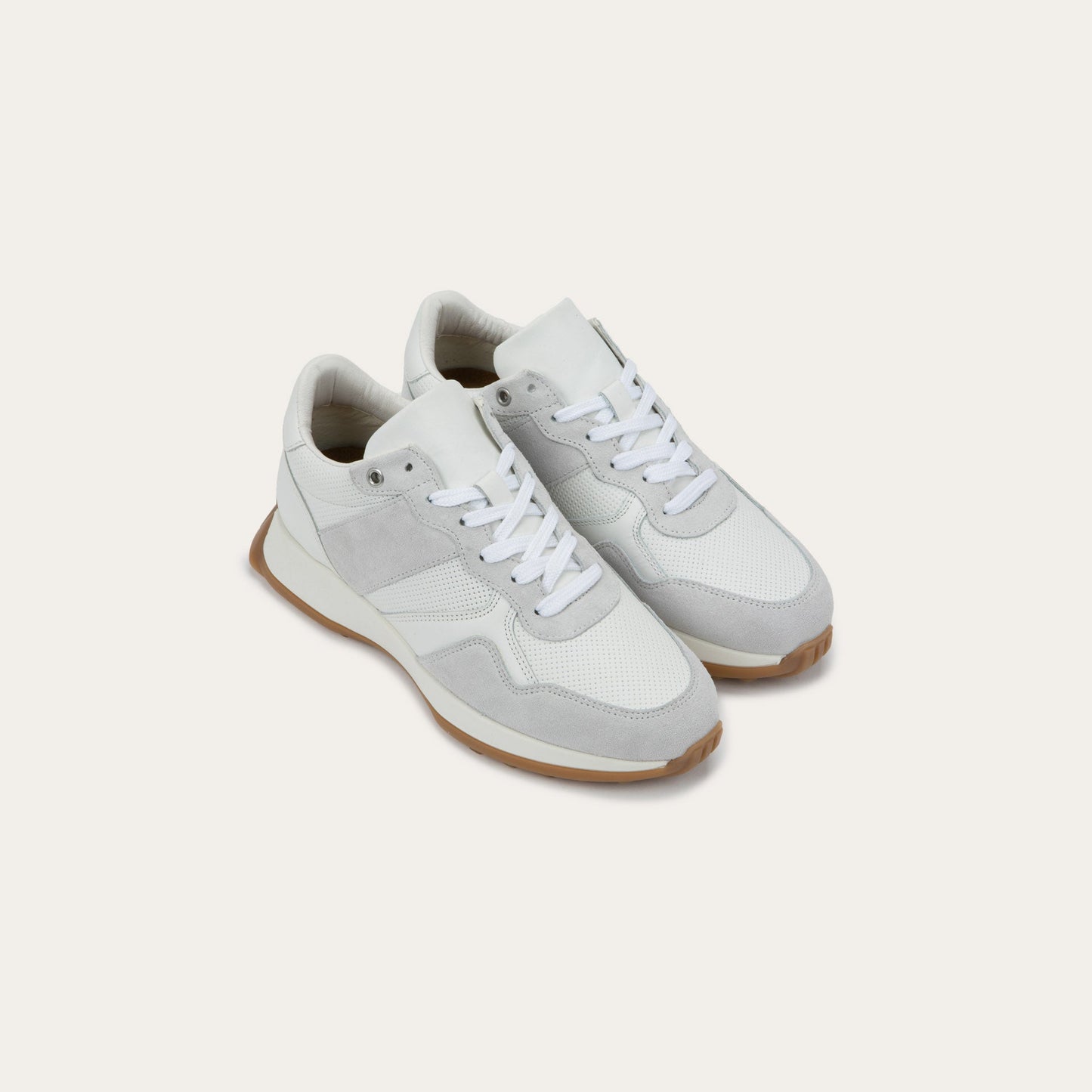 Pair of of a multi-material white lace up sneakers.