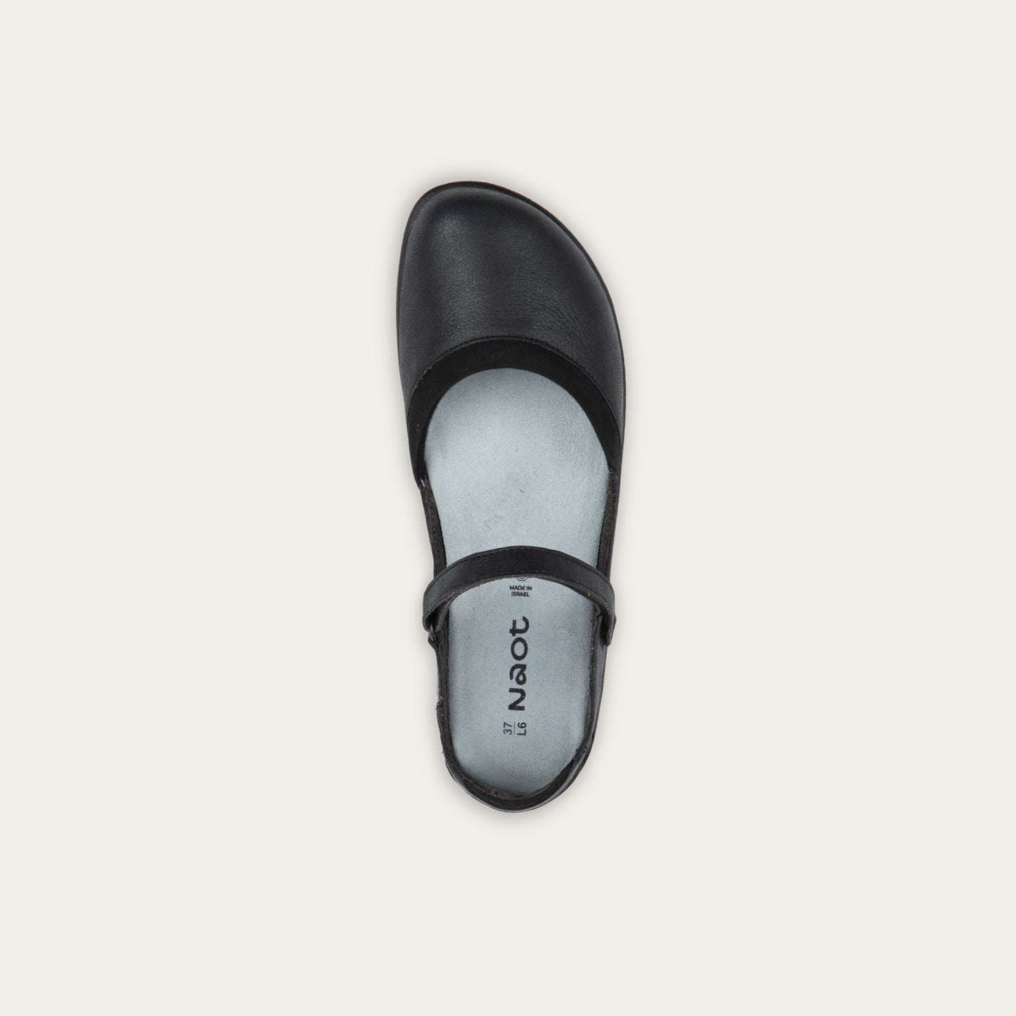Top view of a black Mary Jane featuring contrasting materials and cutouts by the heel on a dark sole.