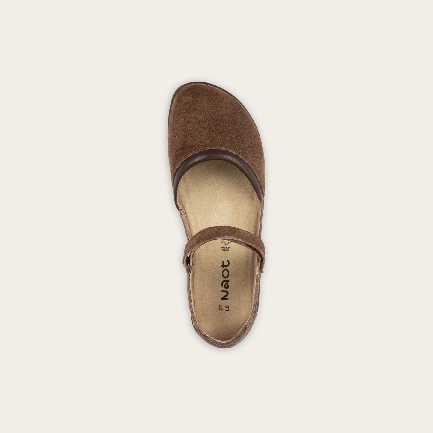 Top view of a brown Mary Jane featuring contrasting materials and cutouts by the heel on a dark sole.