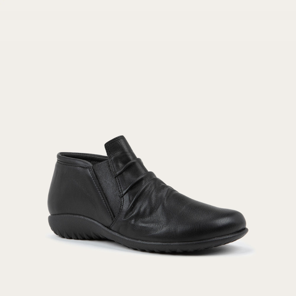 Angled view of a black leather ankle boot with a textured sole.