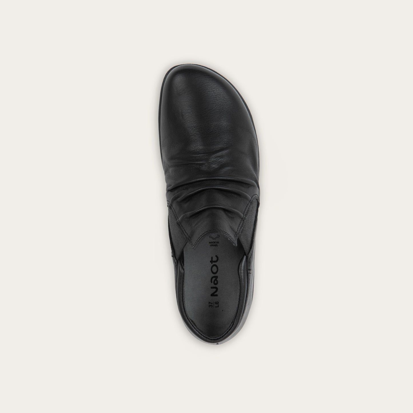 Top view of a black leather ankle boot with a textured sole.