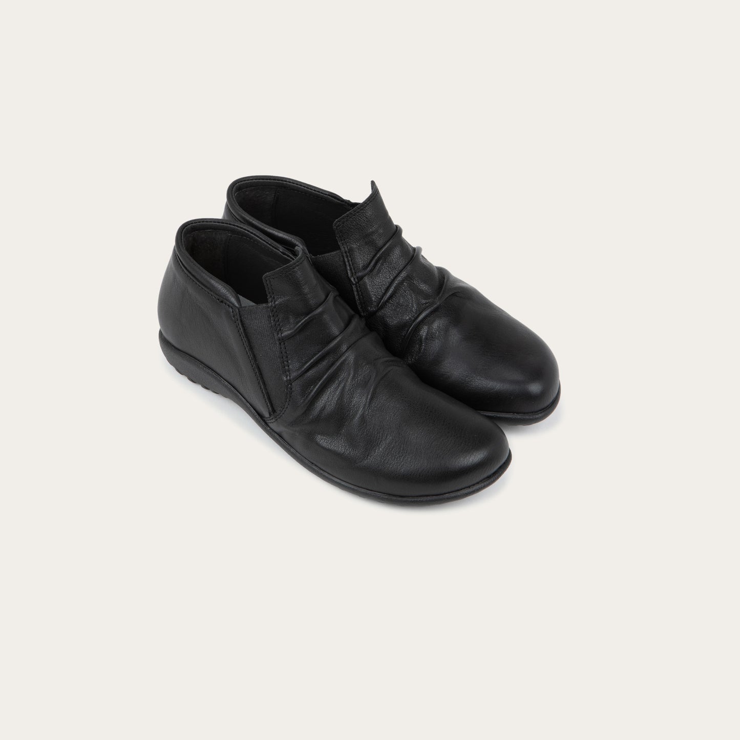 Pair of black leather ankle boots with a textured soles.