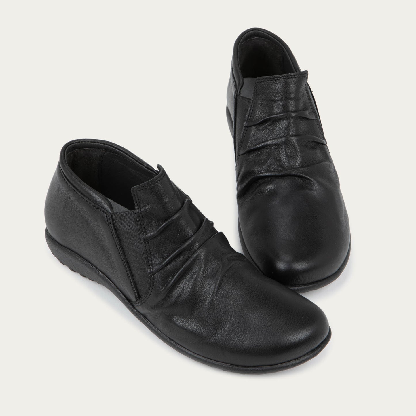 Pair of black leather ankle boots with a textured soles.