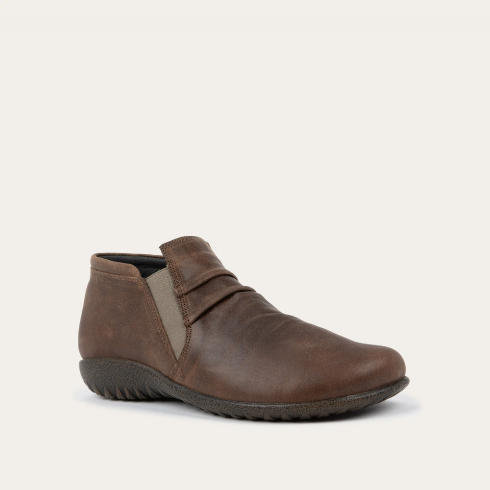 Angled view of a brown leather ankle boot with a textured sole.