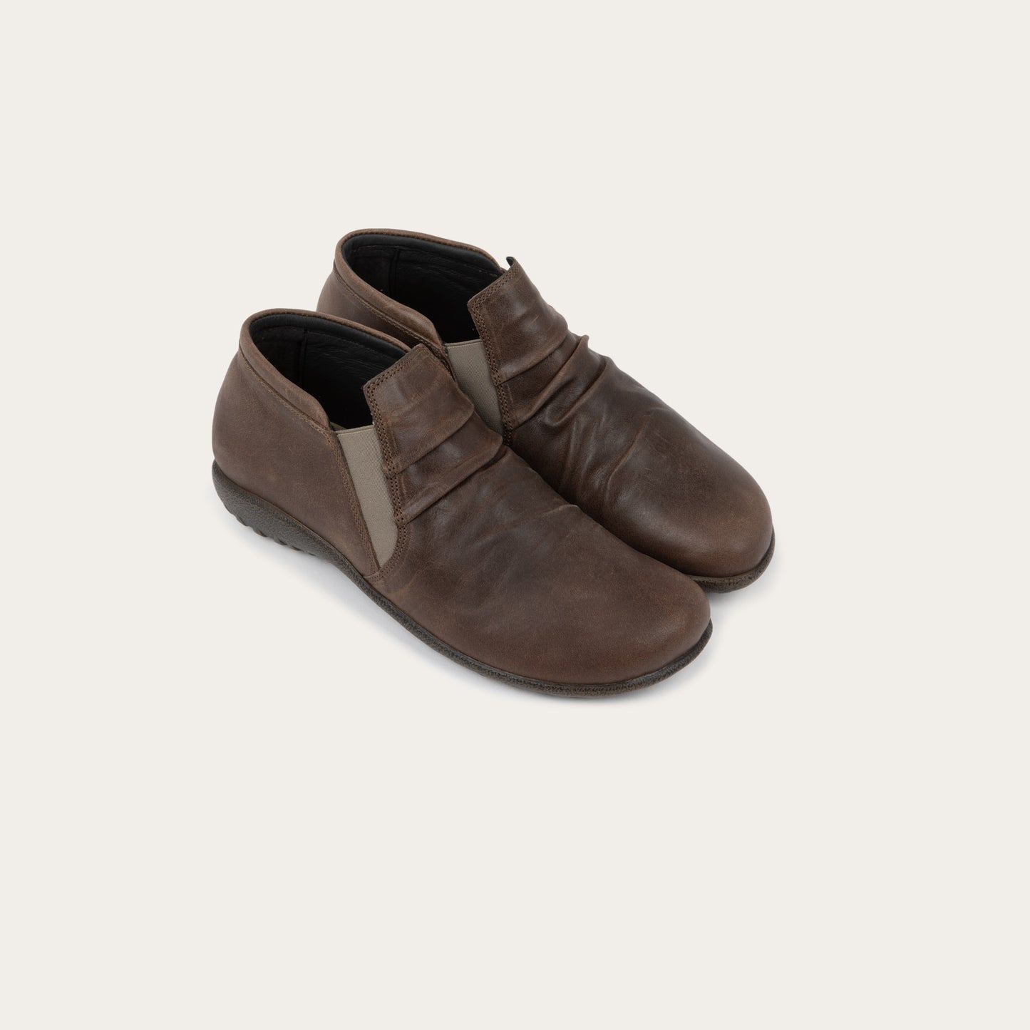 Pair of brown leather ankle boots with a textured soles.