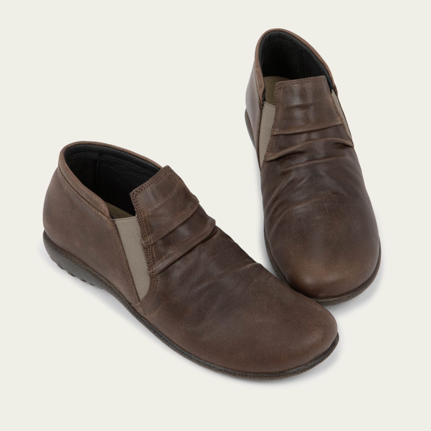 Pair of brown leather ankle boots with a textured soles.