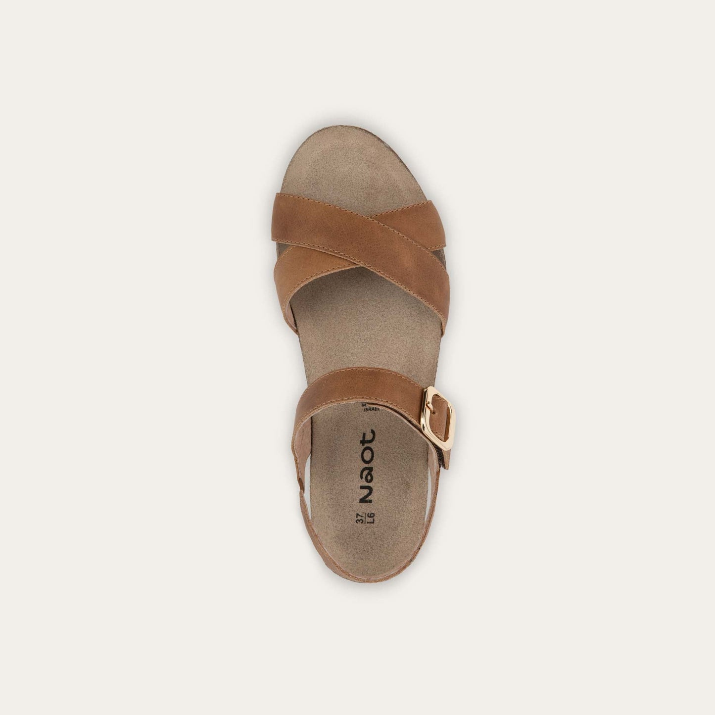 Top view of a cork footbed,  brown wedge sandal with cross straps and a gold buckle on the ankle strap. 