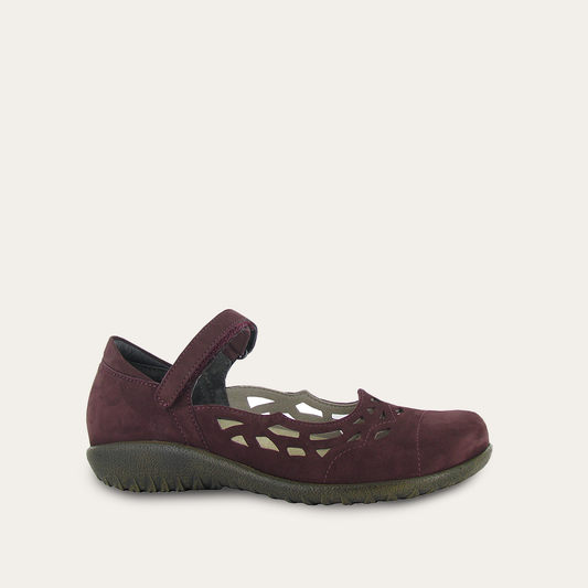 Side view of a women's comfort shoe in a deep red suede, featuring a Mary Jane strap and intricate cutout patterns.