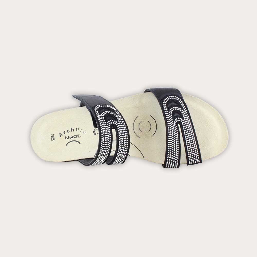 Top view of a black leather slip on wedge sandal with two straps and reivet detailing on a cork footbed,