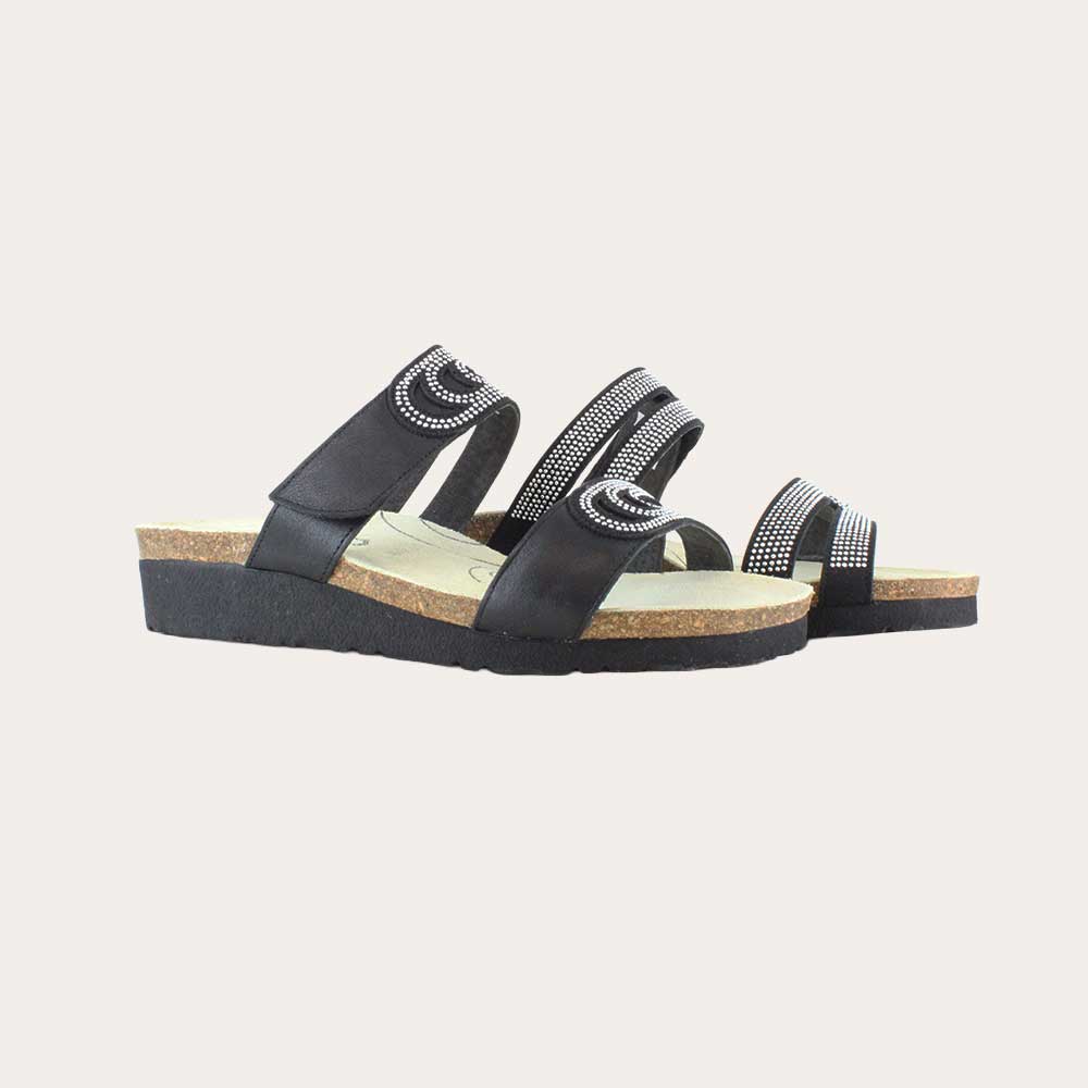 A pair of  black leather slip on wedge sandals with two straps and reivet detailing on a cork footbed,