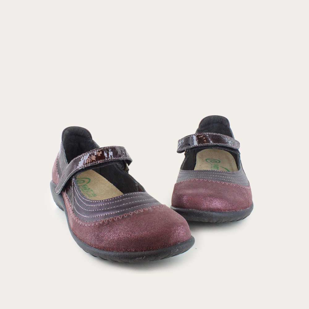 Pair of  purple mary janes featuring contrasing shimmer suede and shiny leather on a black sole.